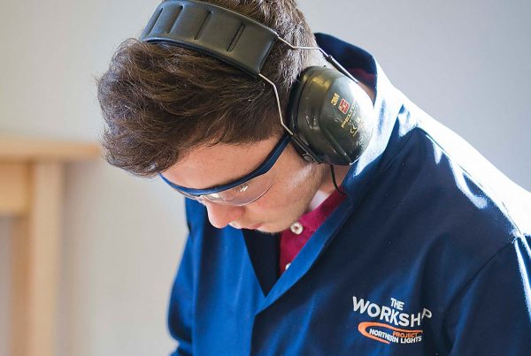 An image of a young male with protective eye glasses and earphones working for the Aberfeldy Community Workshop a charity supported by the Ellis Campbell Foundation, helping disadvantaged young people in Hampshire, London and Perthshire