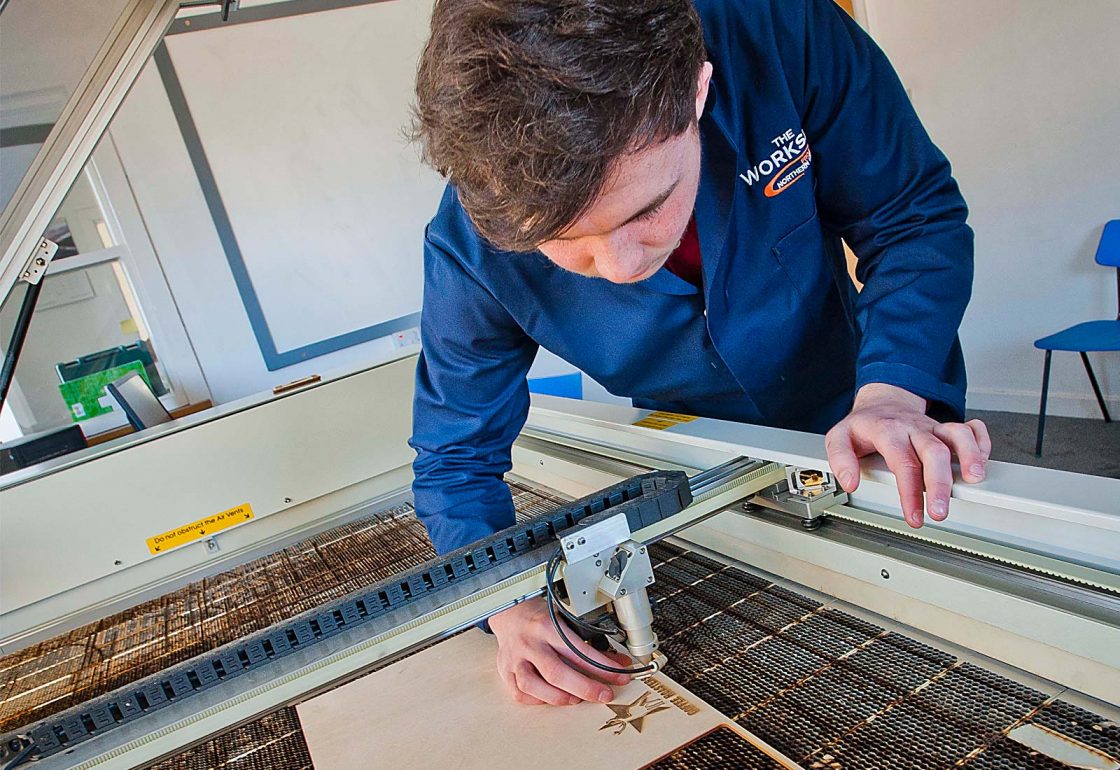 An image of a young male using a laser cutter working for the Aberfeldy Community Workshop a charity supported by the Ellis Campbell Foundation, helping disadvantaged young people in Hampshire, London and Perthshire