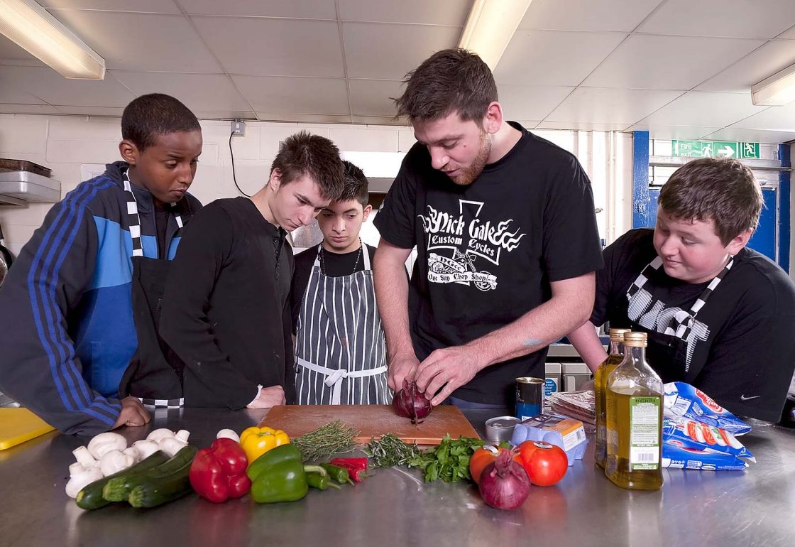 An image of young boys learning to cook and taking part in the Archway project, a motorcycle education and youth centre programme supported by the Ellis Campbell Foundation, helping disadvantaged young people in Hampshire, London and Perthshire