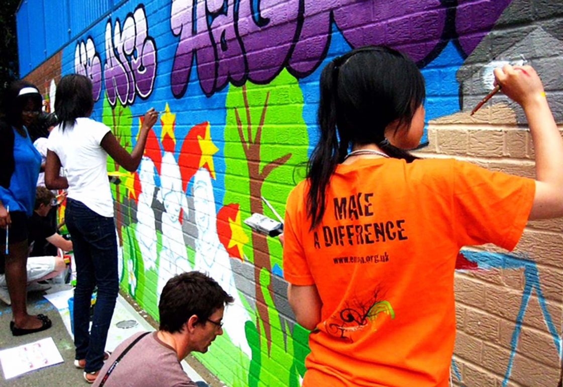 An image of young people painting a graffiti mural on a wall, representing the Envision Community Apprenticeship Programme, a charity supported by the Ellis Campbell Foundation, helping disadvantaged young people in Hampshire, London and Perthshire