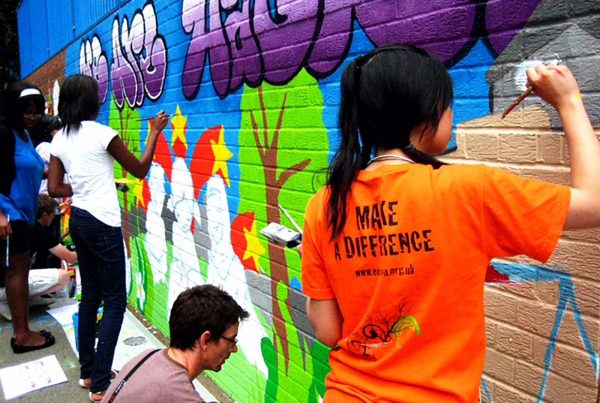 An image of young people painting a graffiti mural on a wall, representing the Envision Community Apprenticeship Programme, a charity supported by the Ellis Campbell Foundation, helping disadvantaged young people in Hampshire, London and Perthshire