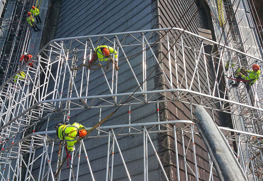 An image of Winchester Cathedral renovations Birth of a Nation project, with men scaling protective scaffolding, a charity supported by the Ellis Campbell Foundation, helping disadvantaged young people in Hampshire, London and Perthshire