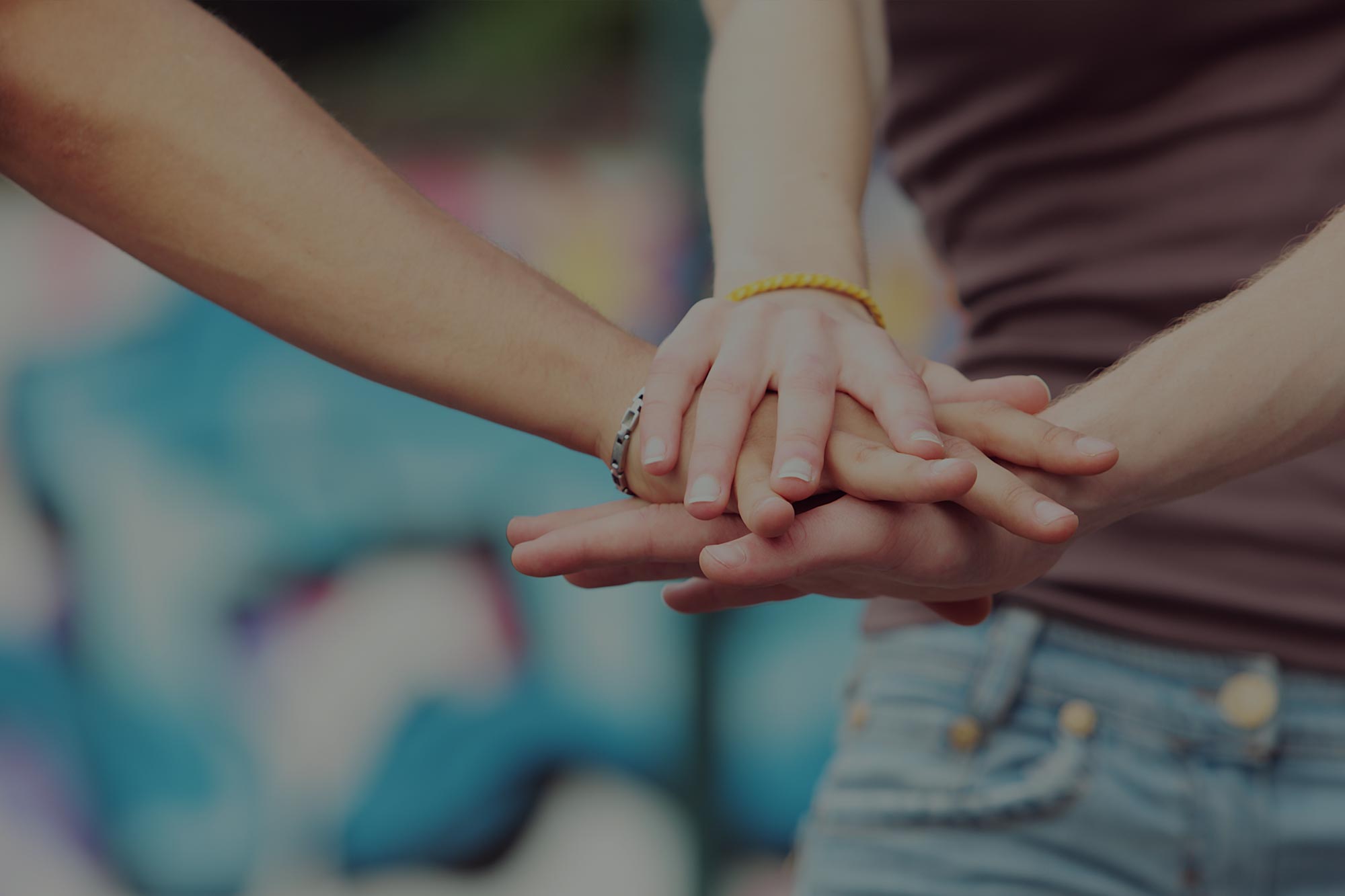 An image of hands of teenagers overlapping to portray helping used for the Ellis Campbell Foundation header, a charity making grants in Hampshire, London and Perthshire - Building Youth Power and Leadership