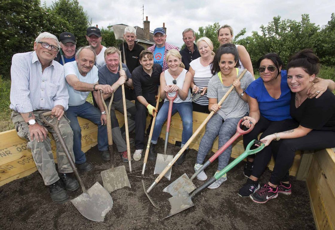 An image of a group of people of mixed ages with spades in hand helping with a gardening project representing Young Enterprise Scotland a grant by the Ellis Campbell Foundation helping disadvantaged young people in Hampshire, London and Perthshire