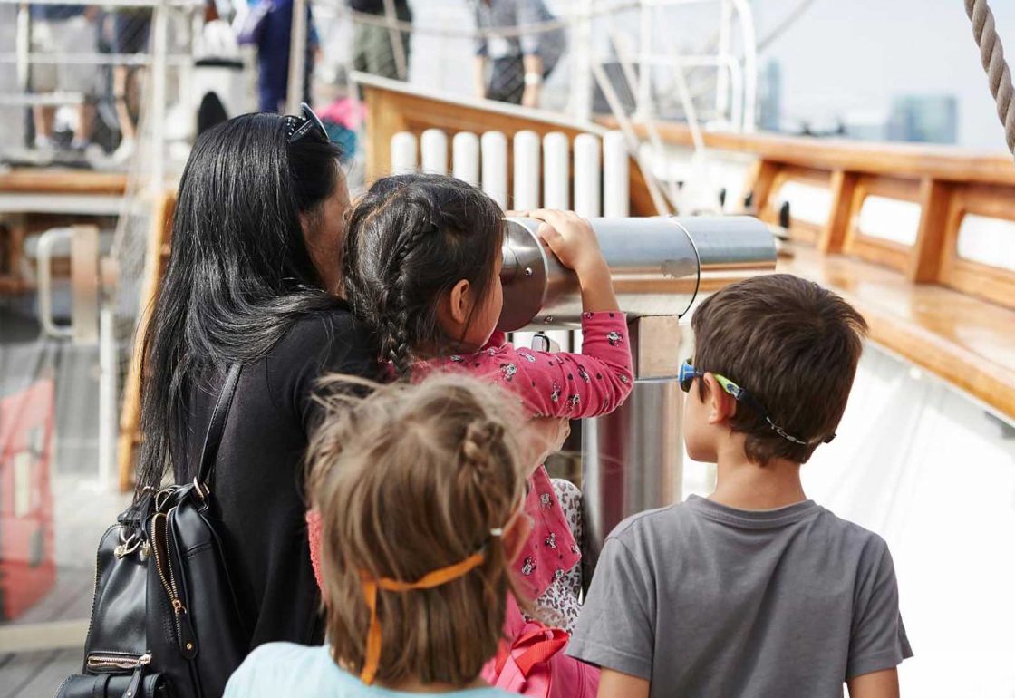 An image of children aboard the Cutty Sark looking through a telescope representing the Lifeboats Conservation Project grant at the Royal Museum Greenwich made by the Ellis Campbell Foundation helping disadvantaged young people in Hampshire, London and Perthshire