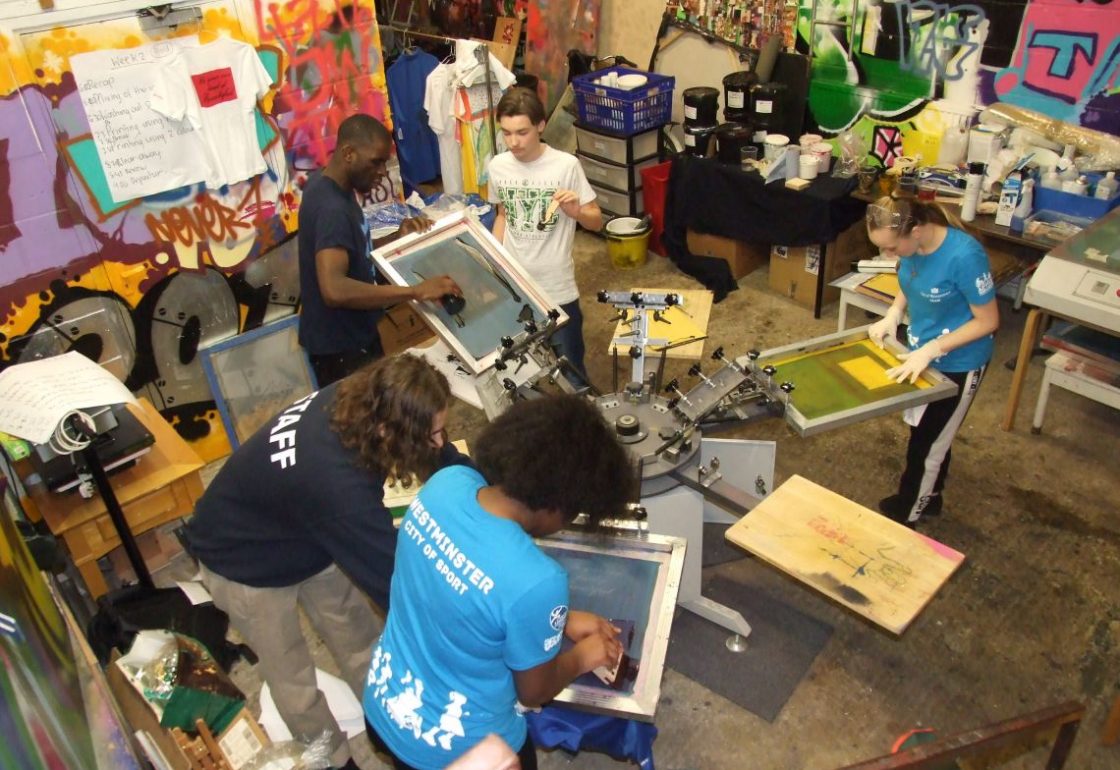 A colour image of young people screen printing at St Andrews Club Community Based Youth Centre supported by The Ellis Campbell Foundation