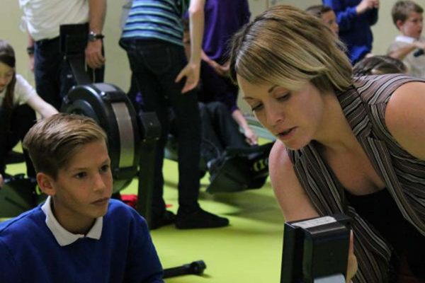 A colour photo of a young people using indoor rowing machines taking part in the Oarsome Chance programme supported by the Ellis Campbell Foundation