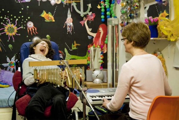 A colour image of young smiling disabled girl playing musical instruments part of Parity for disability supported by the Ellis Campbell Foundation