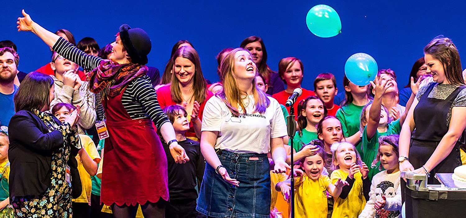 a bright colourful picture showing a group of children performing at the Horsecross Theatre - Perth Autism Youth Theatre supported by The Ellis Campbell Foundation
